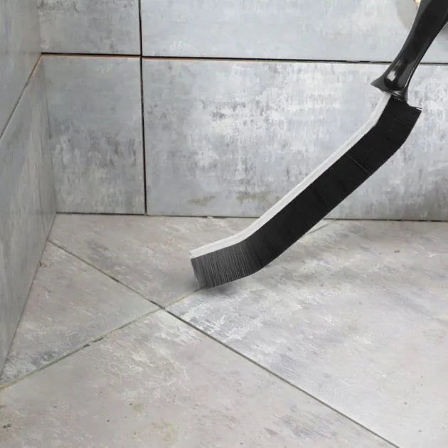 Cleaning brush with bristle head on a tiled floor